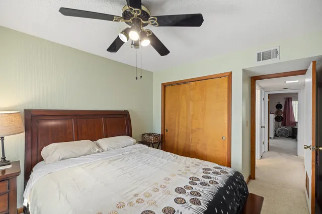 a bedroom with a large bed and a chandelier