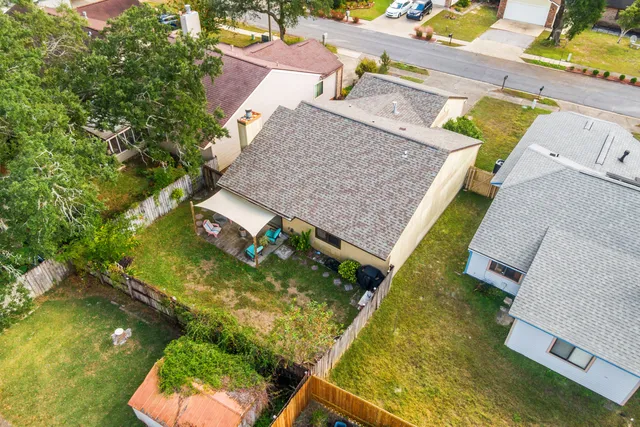 an aerial view of a house with swimming pool and large trees
