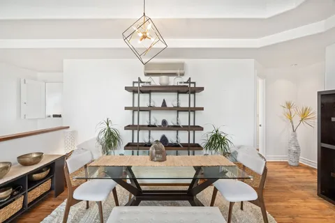 a living room with furniture a chandelier and wooden floor