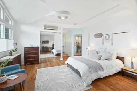 a bedroom with a bed and wooden floor