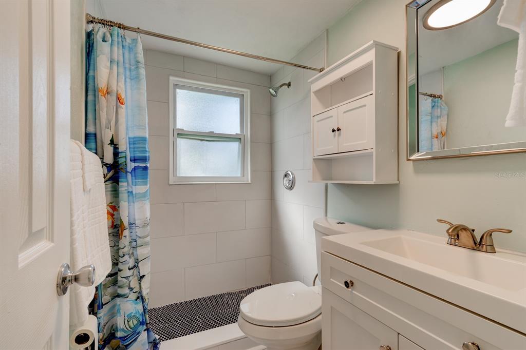 404 Adele Street Edgewater, FL 32132 - Photo 13 of 23 a bathroom with a sink a toilet and shower curtain