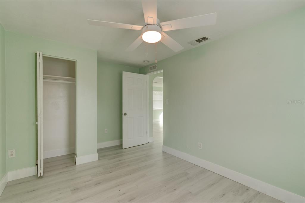 404 Adele Street Edgewater, FL 32132 - Photo 10 of 23 an empty room with wooden floor and a ceiling fan