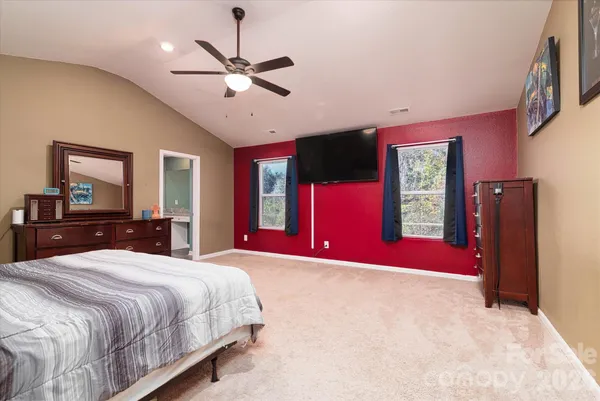a bedroom with a bed chandelier and a window