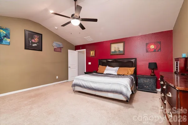 a spacious bedroom with a bed and a ceiling fan