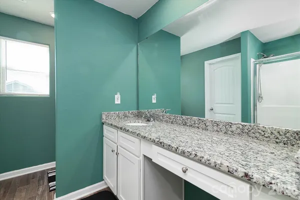 a bathroom with a granite countertop sink and a mirror