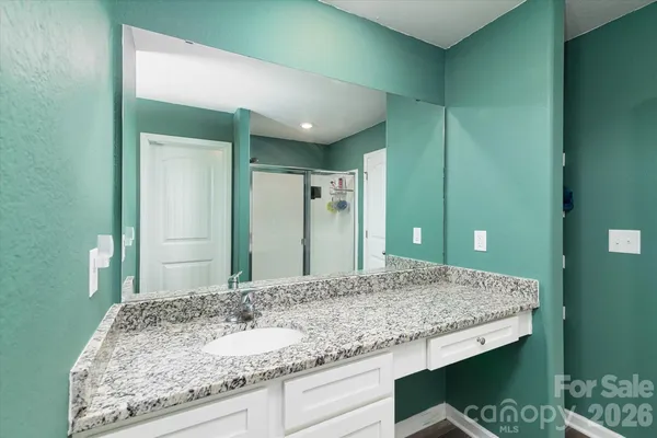 a bathroom with a granite countertop sink and a mirror