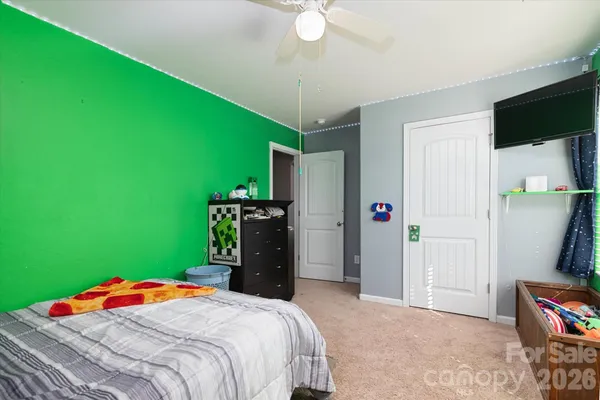a bedroom with a bed and a flat tv screen on dresser