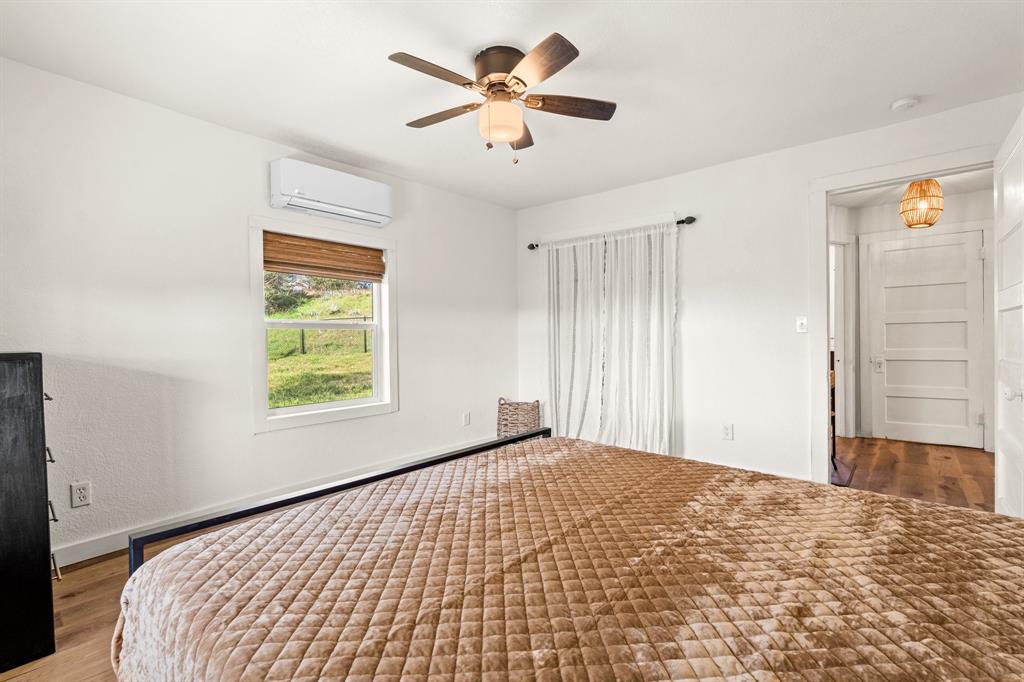 1550 South Stewart Street Azle, TX 76020 - Photo 31 of 35 a bedroom with a bed and a chandelier fan