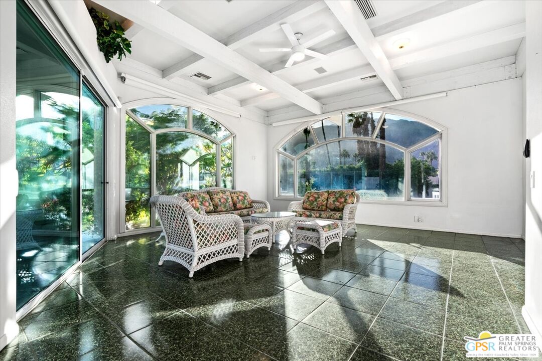875 Tamarisk Road Palm Springs, CA 92262 - Photo 14 of 55 a living room with patio furniture and a floor to ceiling window
