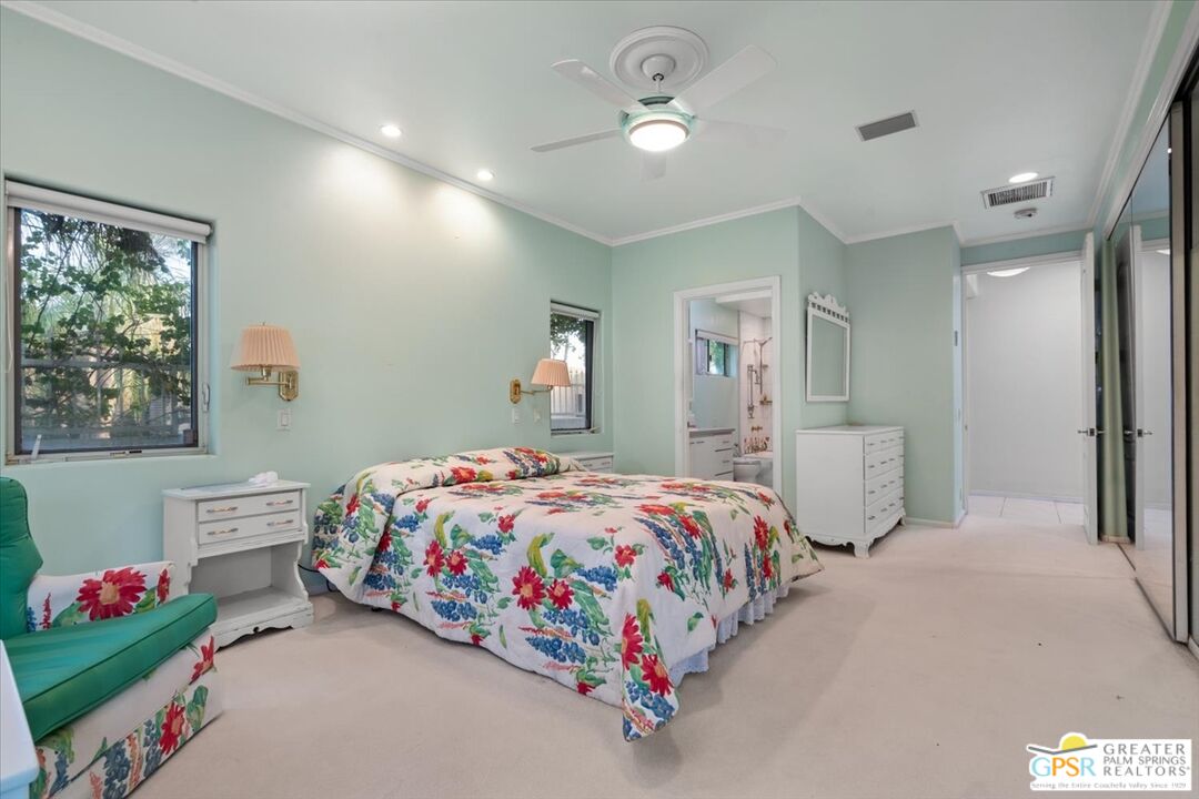 875 Tamarisk Road Palm Springs, CA 92262 - Photo 22 of 55 a bedroom with a bed and a chandelier
