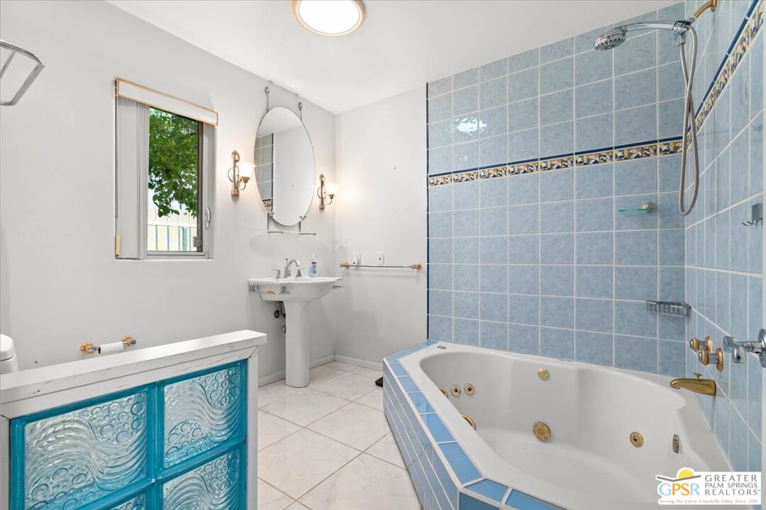875 Tamarisk Road Palm Springs, CA 92262 - Photo 25 of 55 a bathroom with a tub a sink and a window