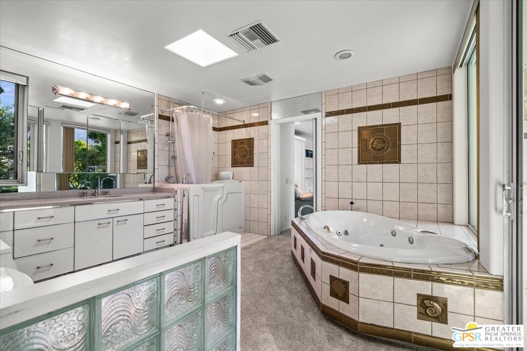 875 Tamarisk Road Palm Springs, CA 92262 - Photo 30 of 55 a bathroom with a tub a double vanity sink and mirror