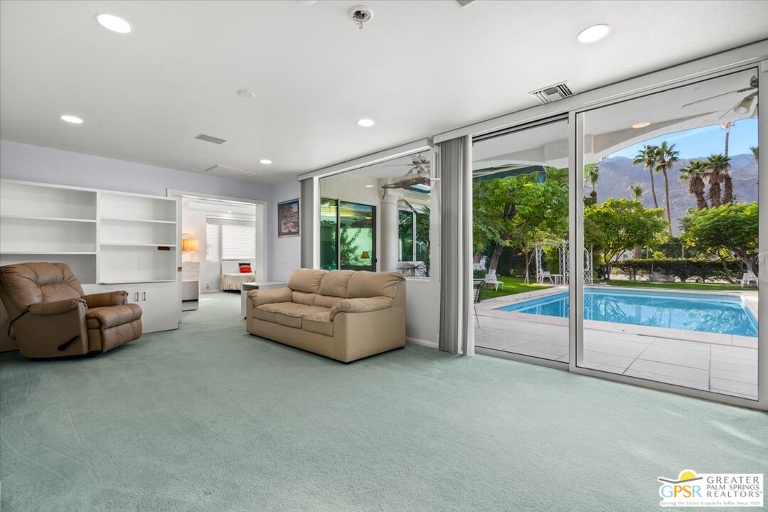 875 Tamarisk Road Palm Springs, CA 92262 - Photo 32 of 55 a living room with furniture and a floor to ceiling window