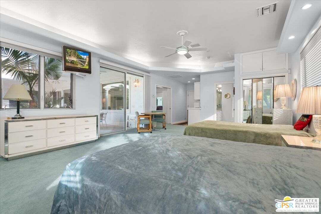 875 Tamarisk Road Palm Springs, CA 92262 - Photo 35 of 55 a spacious bedroom with a bed a dresser and large mirror