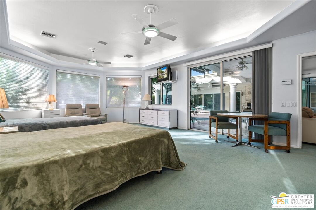 875 Tamarisk Road Palm Springs, CA 92262 - Photo 37 of 55 a spacious bedroom with a bed a table and large windows