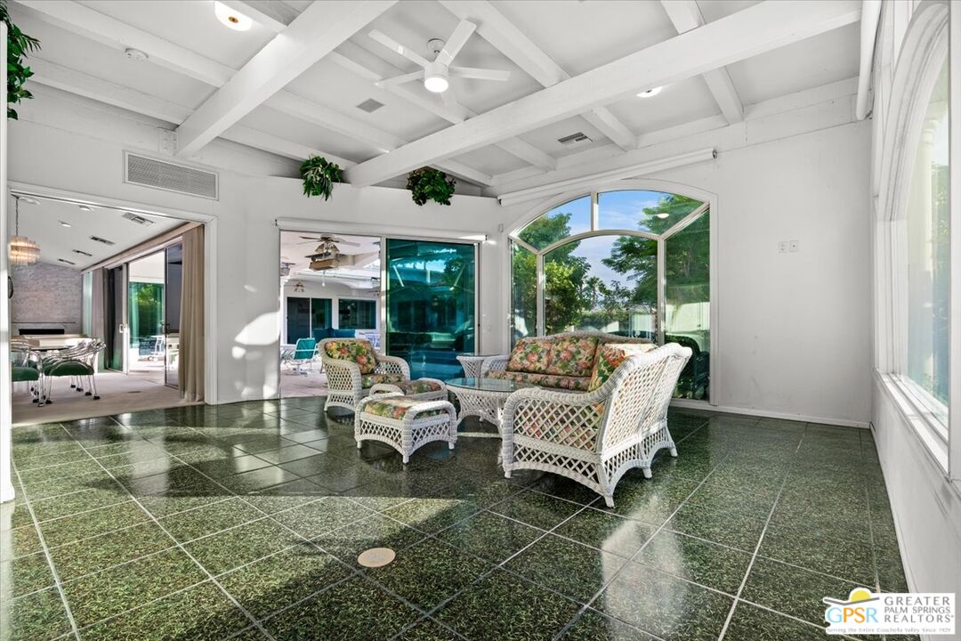 875 Tamarisk Road Palm Springs, CA 92262 - Photo 4 of 55 a living room with patio furniture and a large window