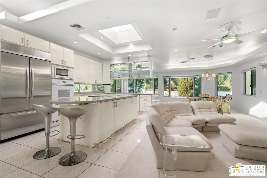 875 Tamarisk Road Palm Springs, CA 92262 - Photo 7 of 55 a living room with lots of white furniture and a chandelier