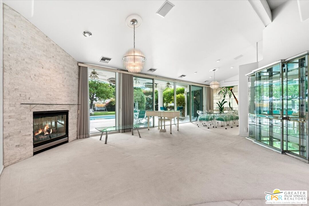 875 Tamarisk Road Palm Springs, CA 92262 - Photo 8 of 55 a view of an empty room with windows and a fireplace