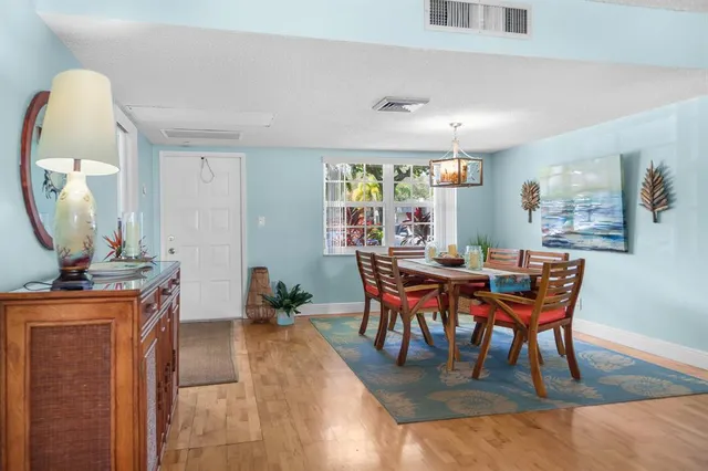 a dining room with furniture a rug and a mirror