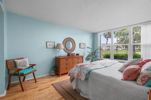 a bedroom with a bed a window and a potted plant on table