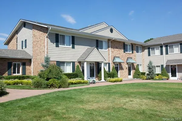 a front view of a house with a yard and trees