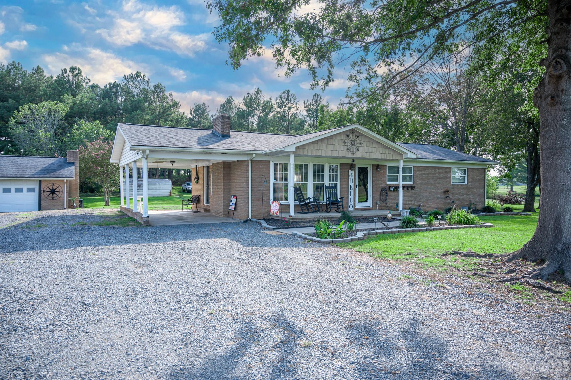 a front view of a house with a yard and trees