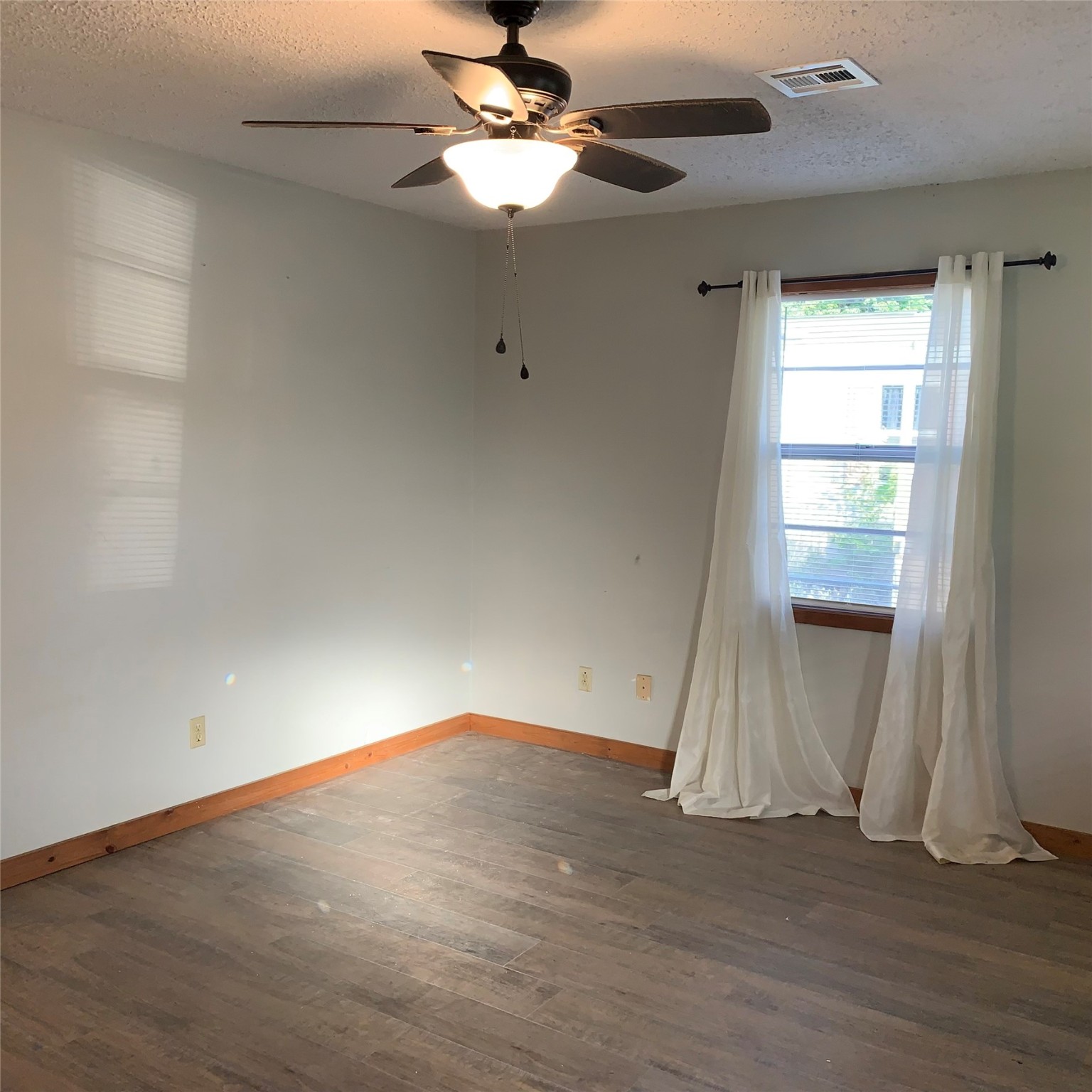 324 Persimmon Road Onalaska, TX 77360 - Photo 5 of 41 an empty room with wooden floor fan and windows