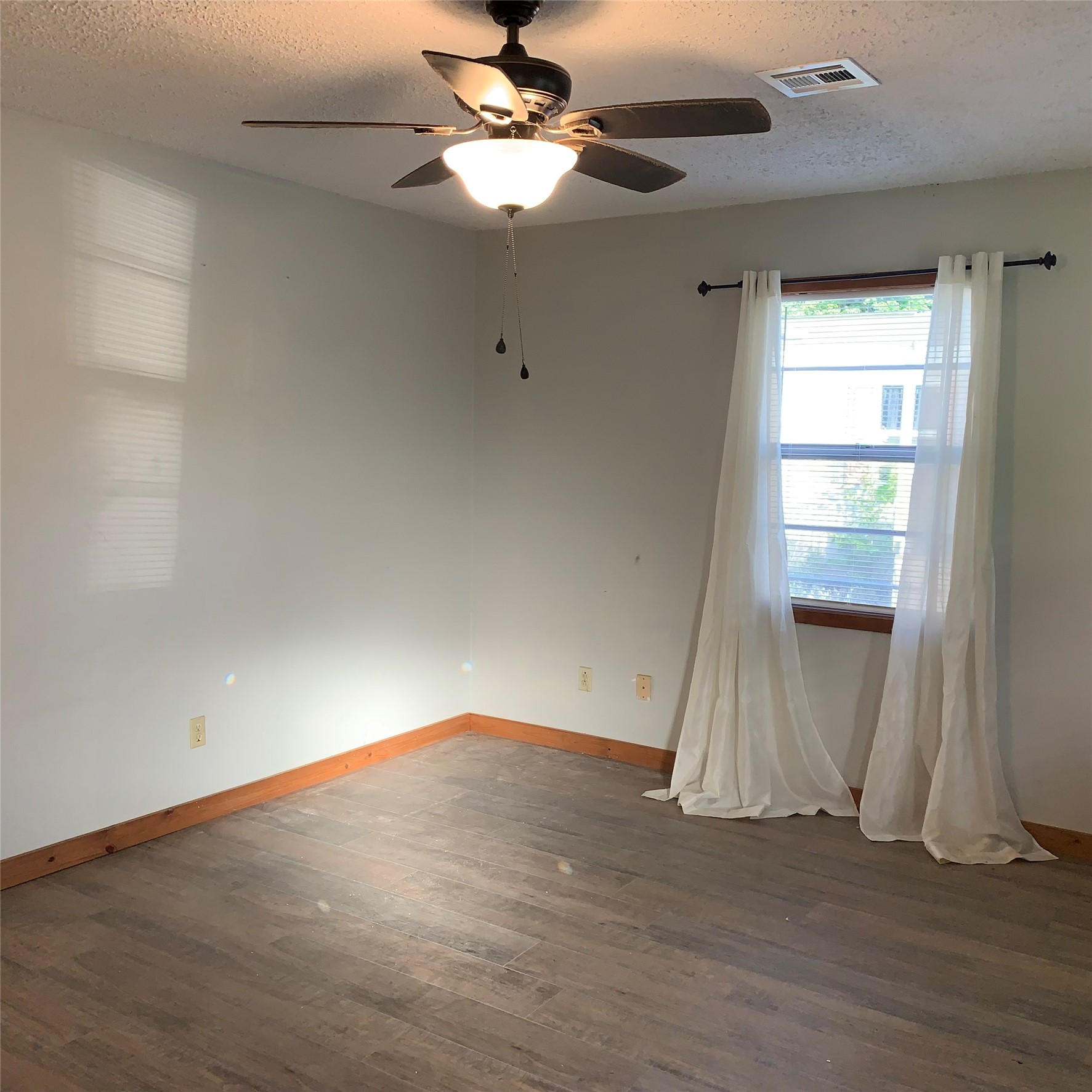324 Persimmon Road Onalaska, TX 77360 - Photo 5 of 41 an empty room with wooden floor fan and windows
