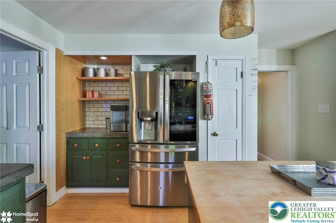 5832 Kernsville Road Orefield, PA 18069 - Photo 13 of 49 A well-equipped kitchen features a built-in pantry alcove with open shelving next to modern appliances.