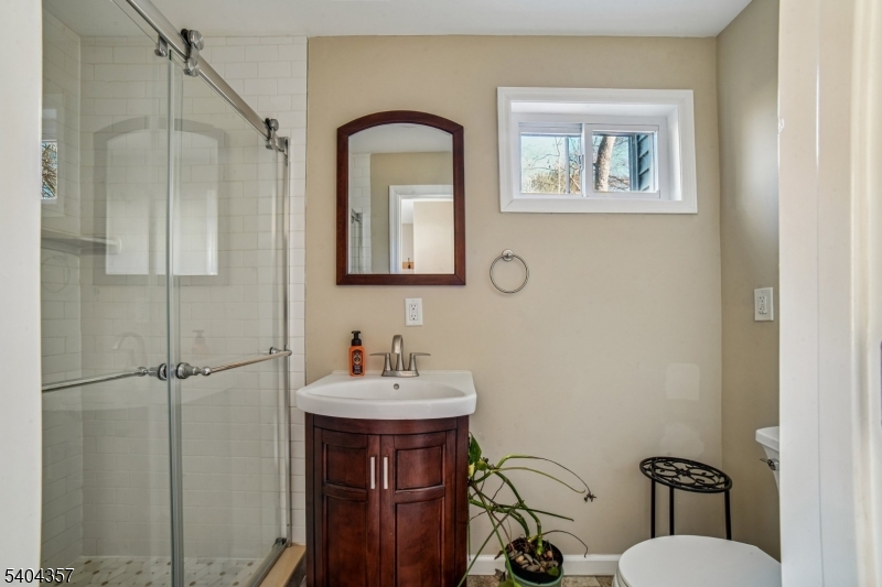 169 Diamond Spring Road Denville, NJ 07834 - Photo 8 of 31 a bathroom with a toilet a sink and mirror