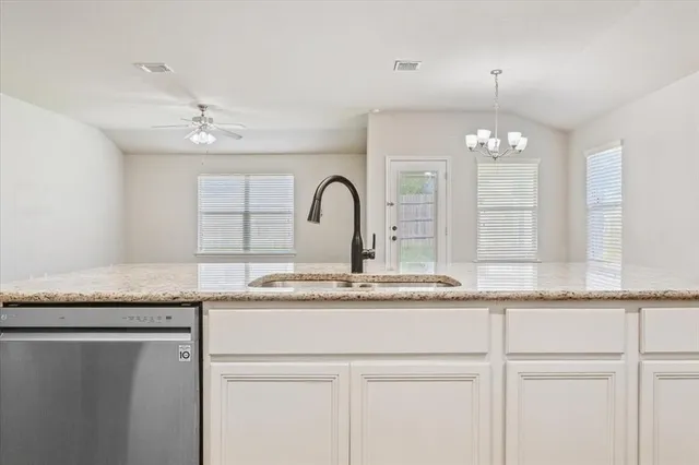 a kitchen with granite countertop stainless steel appliances a sink and cabinets