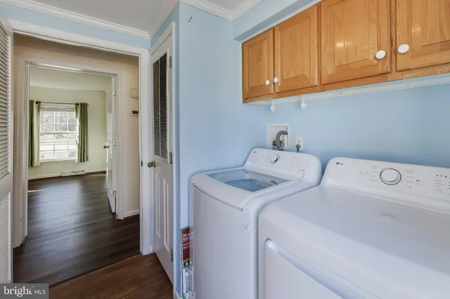 a utility room with wooden floor washer and dryer