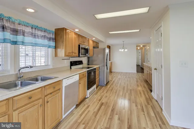 a view of a room with wooden floor a ceiling fan and windows