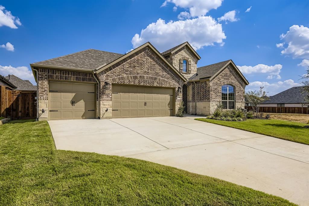 1809 Flowerfield Lane Mansfield, TX 76063 - Photo 2 of 29 French country inspired facade with brick siding, a shingled roof, a garage, and concrete driveway