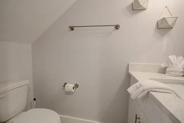 a white toilet sitting next to a shower