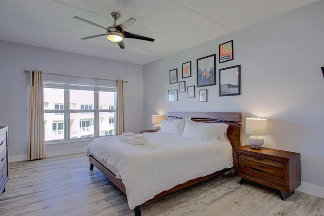 a bedroom with a bed chandelier and a window