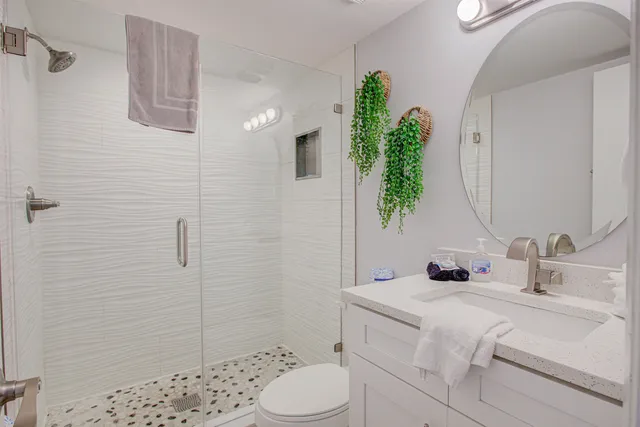 a bathroom with a sink a toilet and shower