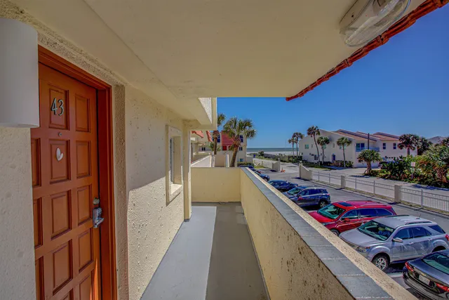 a view of a house with a yard and potted plants