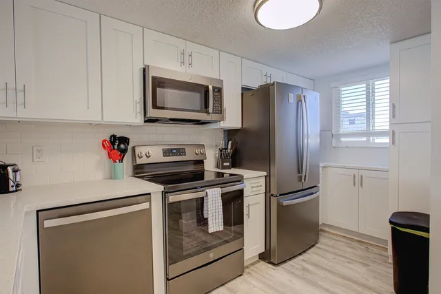 a kitchen with stainless steel appliances granite countertop a refrigerator stove and microwave
