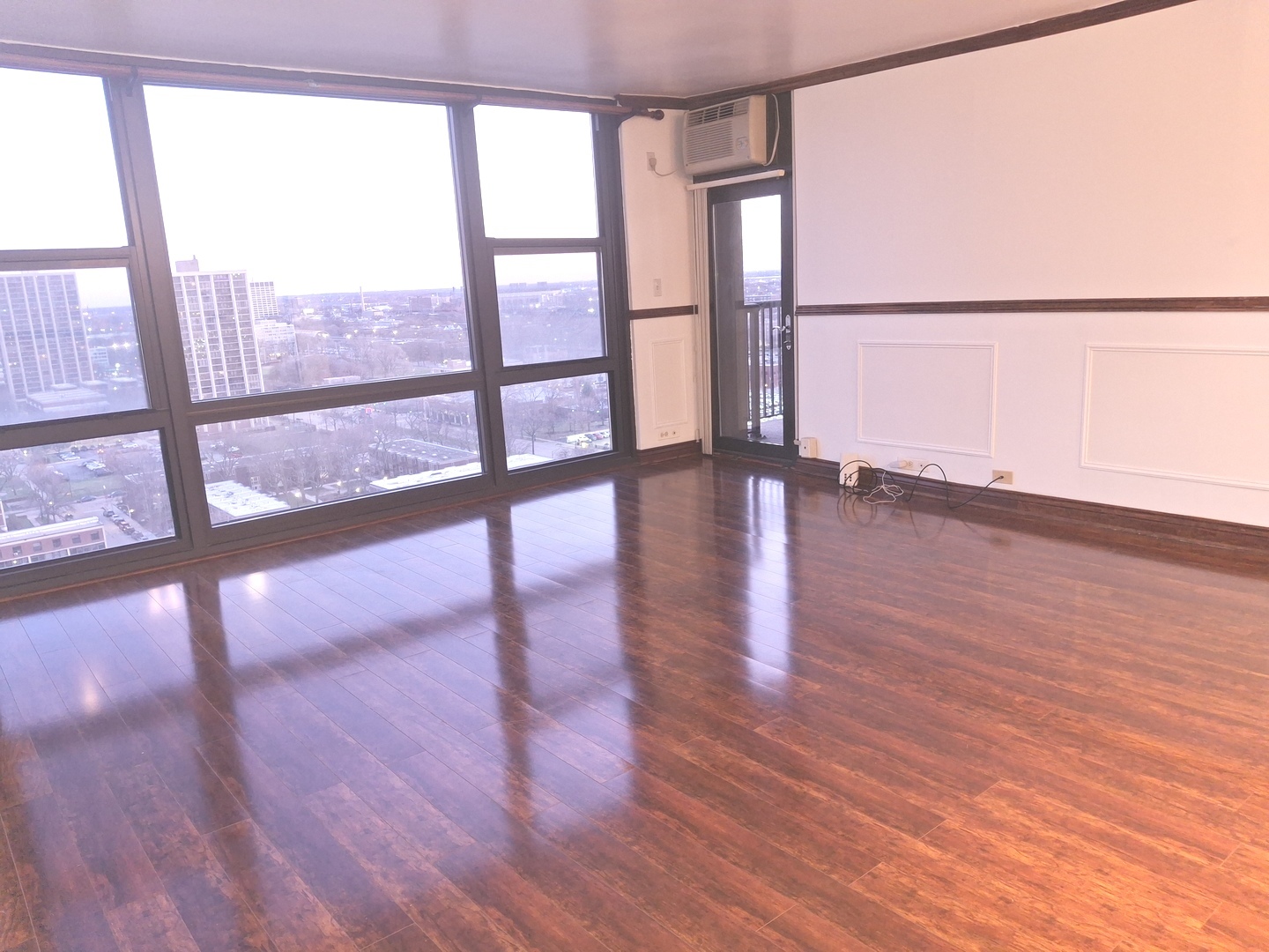2605 South Indiana Avenue, Unit 1909 Chicago, IL 60616 - Photo 3 of 19 a view of an empty room with wooden floor and a window