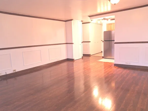 a view of a big room with wooden floor and windows