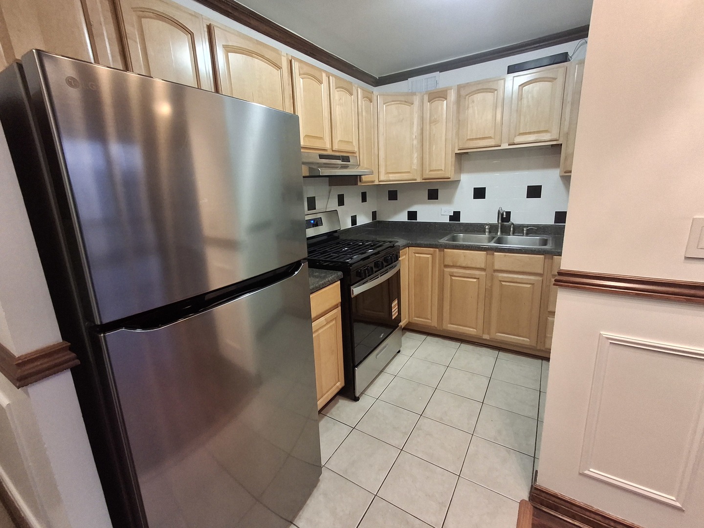 2605 South Indiana Avenue, Unit 1909 Chicago, IL 60616 - Photo 6 of 19 a kitchen with granite countertop a refrigerator a sink a stove and white cabinets