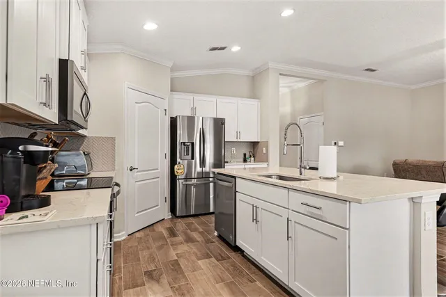 a kitchen with sink stove and cabinets
