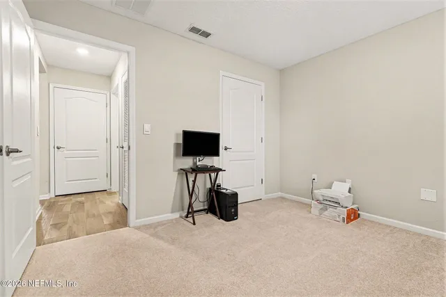 a bedroom with a bed and a painting on the wall