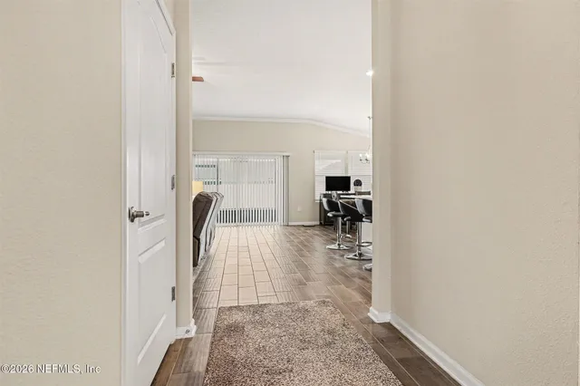 a view of a hallway with furniture and floor to ceiling window