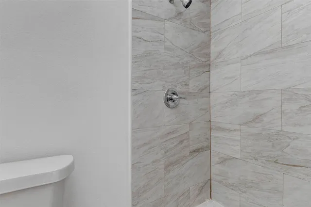 a bathroom with a toilet and shower