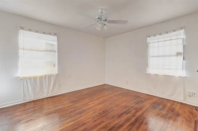 wooden floor in an empty room with a window
