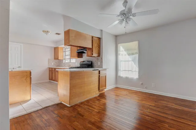 a kitchen with stainless steel appliances granite countertop a sink a stove a refrigerator cabinets and wooden floor