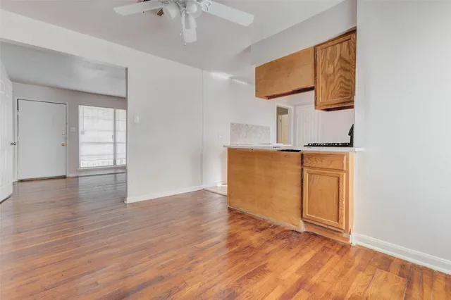 an empty room with wooden floor and cabinet