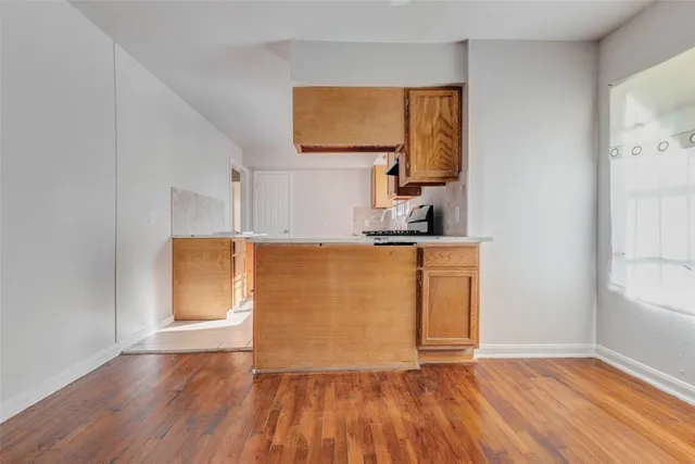 a view of a kitchen with wooden floor and a sink